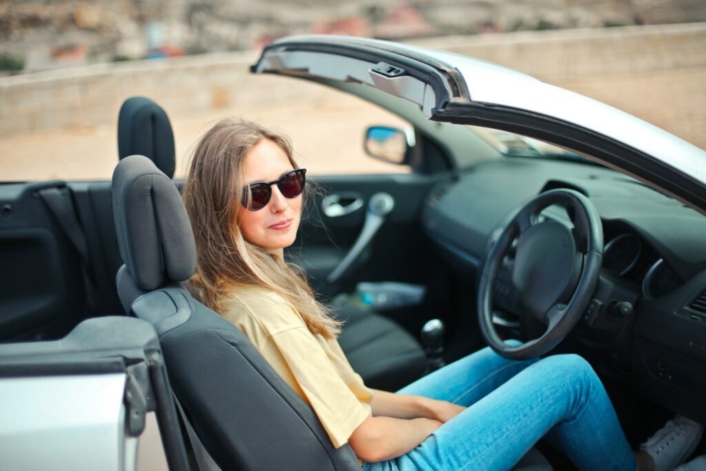 smiling woman sitting on black and white vehicle